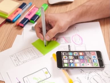 A picture of a person drawing UI designs.